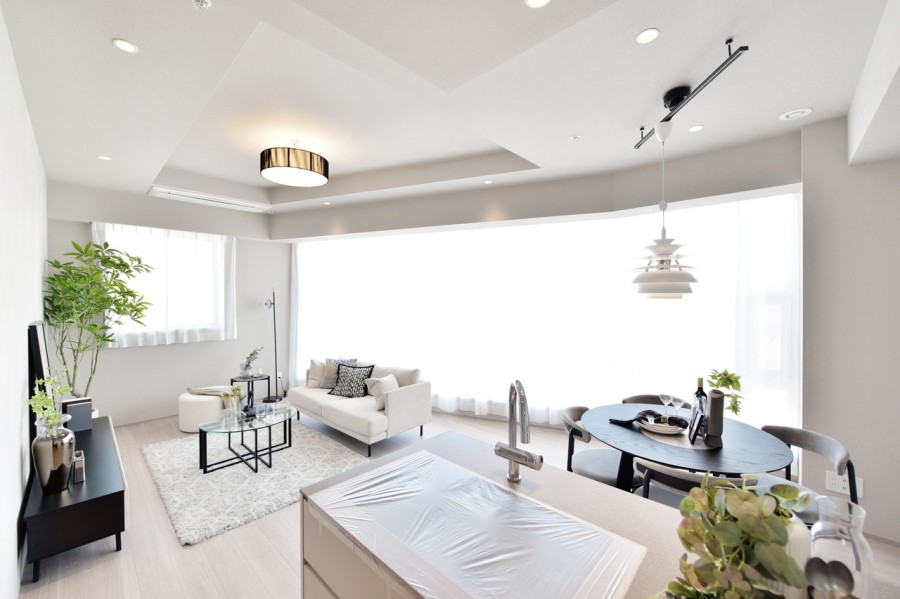 32階部分の北東角住戸、二面採光で優しい光が差し込むLDKです。約18.2帖の広さがあり、床暖房を完備していますので、家族がゆったりとくつろぐことができます。シンプルな内装なのでインテリア選びも楽しんでいただけます。