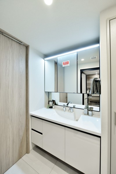 洗面台は三面鏡裏や、収納棚、吊戸棚を設置し、整理しやすい空間になっています。タッチレススイッチを採用していますので、手を触れずに照明をonoffでき、清潔に使用できます。