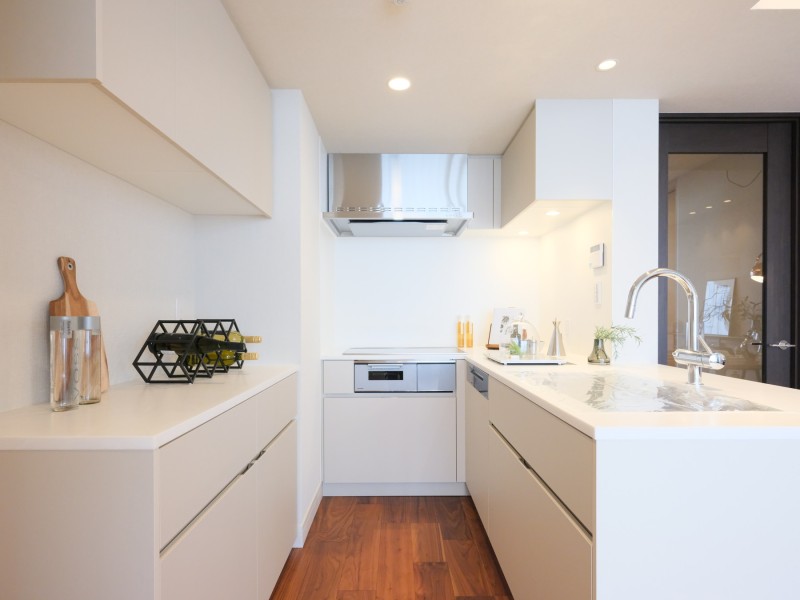 白を基調としたキッチンは田中工藝製のオリジナルシステムキッチンです。内装と調和した色合いで、空間に統一感があります。豊富な収納を備え、お料理グッズもすっきりと整理できます。