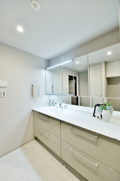 大きな鏡で朝の身だしなみチェックもしやすい広々とした洗面台です。タッチレススイッチ採用で手を触れずに照明をonoffできます。三面鏡裏や引き出しなど収納もたっぷりで、いつも清潔な空間を保てます。