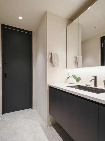 洗面室には田中工藝製の洗面化粧台と収納棚を設置いたしました。収納棚にはリネン類やお洗濯グッズを収納でき、扉がついているため外から見えません。