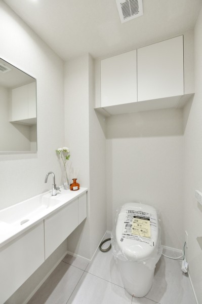 トイレは下階、上階に2か所設置しています。どちらにも鏡と手洗いカウンターを備え付けましたので、家族やゲストが気兼ねなく清潔に使用することができます。吊戸棚を設置していますので、小物類の収納にも便利です。