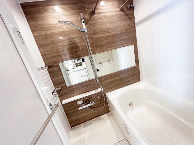 光沢のある木目調のアクセントパネルが高級感を漂わせるバスルームです。暖房・涼風・換気・乾燥機能付きで1年中快適なバスタイムをお楽しみいただけます。