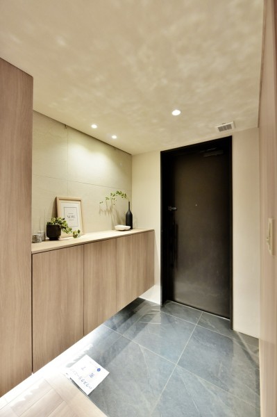 玄関には主張しすぎない色合いや脈模様が美しいタイルを敷設し、さりげなく高級感ある空間を演出しています。間接照明が足元を照らし、家族やゲストをあたたかく迎え入れてくれます。