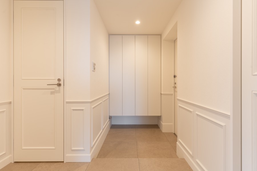 モールディングのデザインが映えるホワイト基調の玄関スペースです。人感センサー照明のため、いつでも明るい空間が出迎えてくれる設計です。