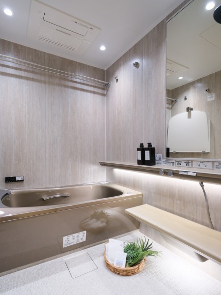 ラグジュアリーなバスルームにはヘッドレスト付き浴槽に加え、肩湯・腰湯の〈楽湯〉機能と、調光調色システムを採用いたしました。洗練されたフォルムと自然を感じる質感が、安らぎの時間へと誘います。