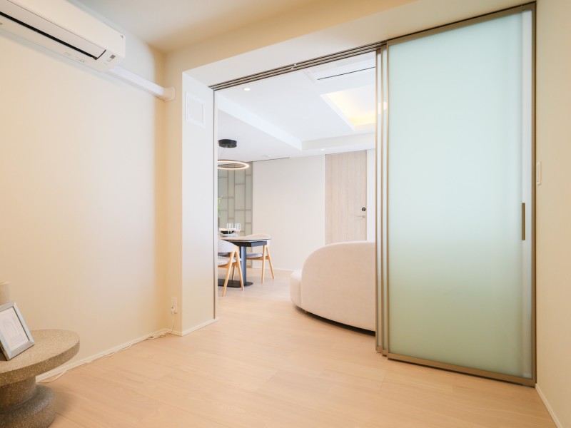 洋室3はシンプルで洗練された佇まいを感じさせるお部屋です。透け感のある引き戸から柔らかな光が差し込みます。開口部の広さより空間の広がりを感じられますね。