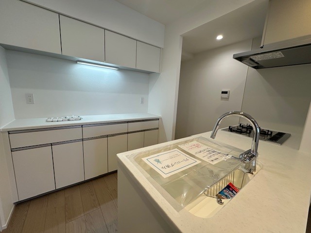 キッチンの背面には、お揃いのデザインのカップボードが設置されております。吊戸棚と足元に収納棚があり、食器や調味料など様々なものを収納することができます。