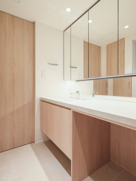 使うたびに心に気品とゆとりを与えてくれるホテルライクな洗面化粧台は、キッチンと同じくオリジナルで造作した設備です。広々としたカウンタースペースの下にはチェアなどを配置することもできます。