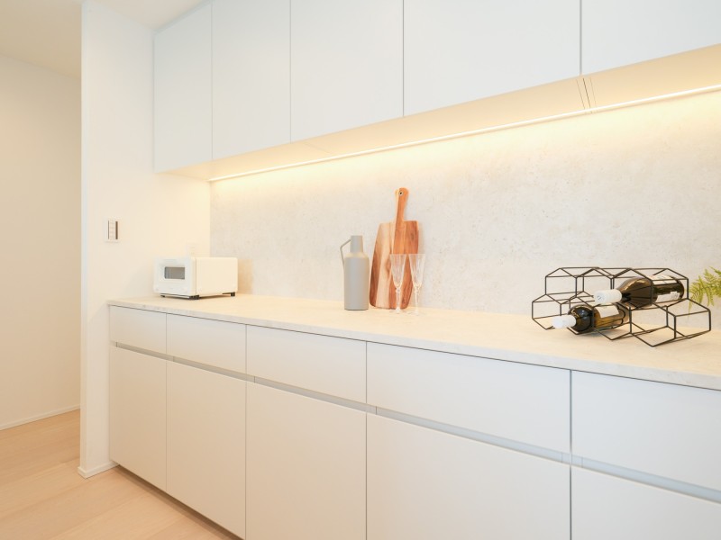 キッチンの背面にはお揃いのデザインのカップボードを設置しました。吊戸棚と足元に収納棚があり、食器や調味料など様々なものを収納することができます。