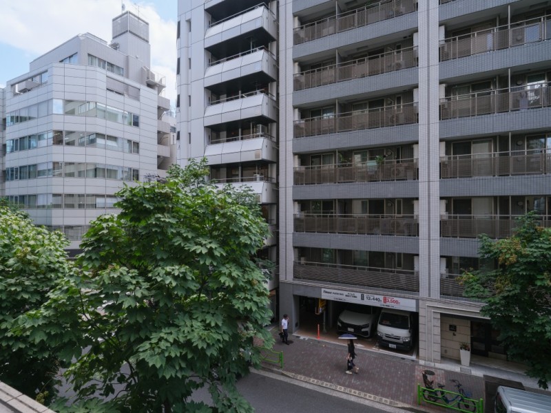 周辺にはマンションやオフィスビルが建ち並び、都心ならではの街並みを身近に感じられる眺望です。足元には街路樹の緑も見え、景色に彩りを添えています。