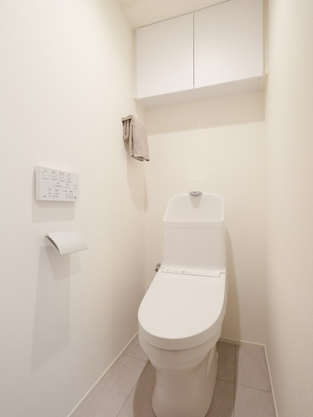 シンプルなデザインの中に安らぎが感じられるレストルームです。吊戸棚にはトイレットペーパーや掃除用具を収納でき、生活感を抑えたすっきりとした空間を実現します。