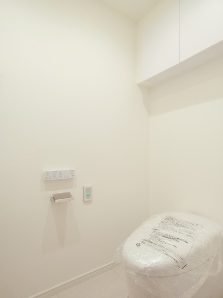 上部収納を備えたすっきりとしたトイレ空間です。白を基調とした清潔感のある内装で、お手入れのしやすさにも配慮されています。