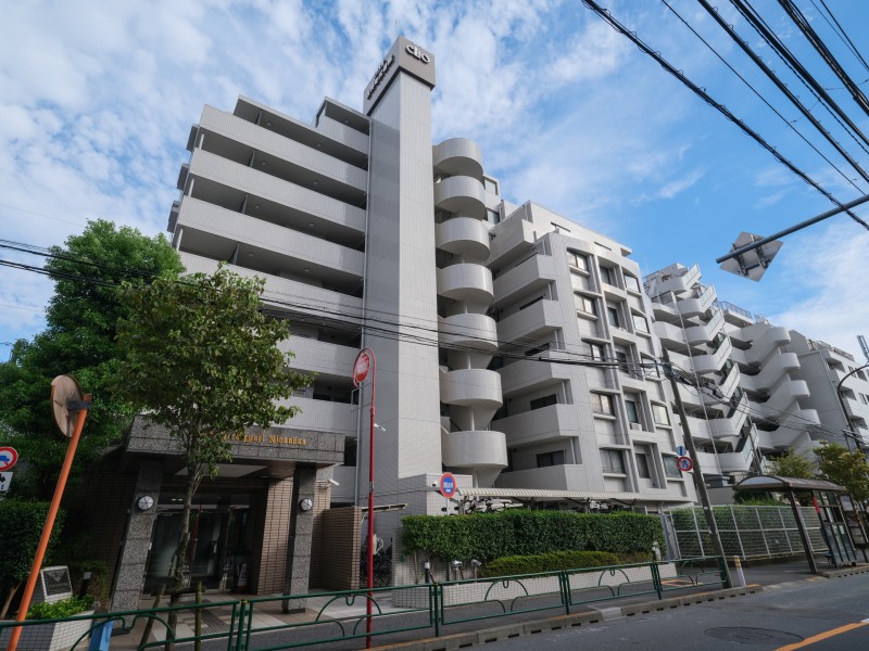 白を基調としたタイル貼りの端正なデザインが印象的で、歩道に面した整った街並みに調和しています。豊かな緑に寄り添いながら、日常生活での利便性も確保した住環境です。