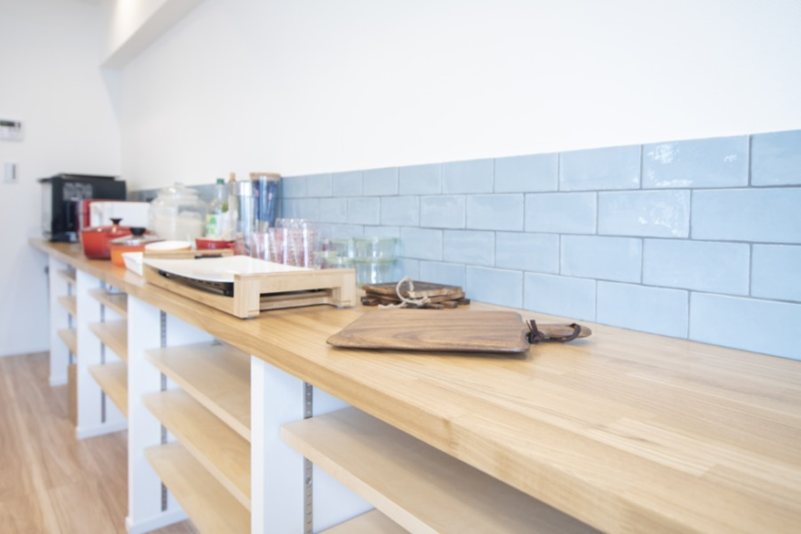 アイランドキッチンの背面に長いカウンター収納を設けた事例