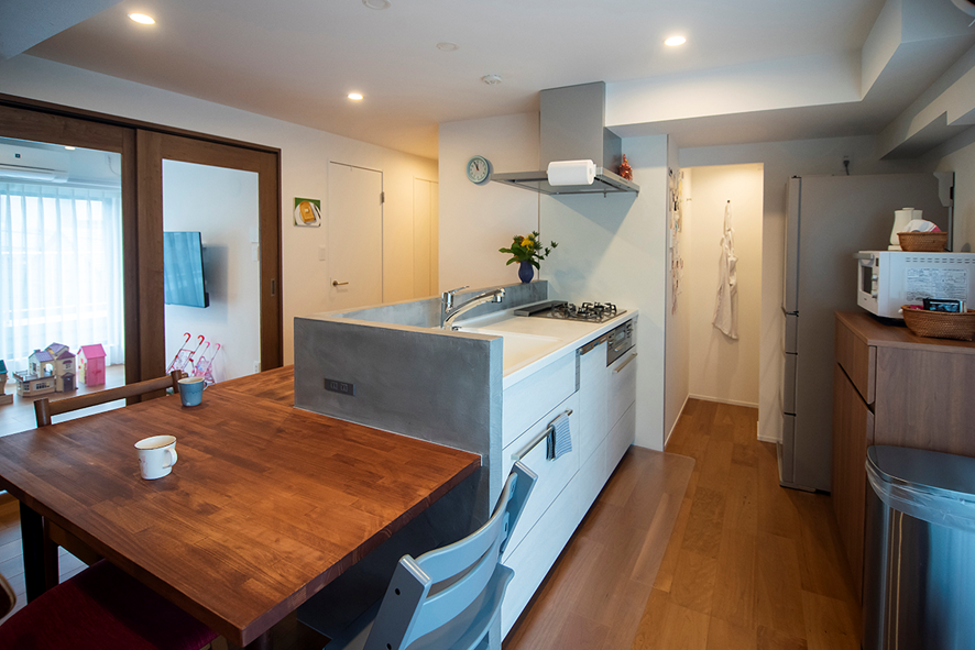 造作L型カウンターを設けた手元を隠すペニンシュラキッチン